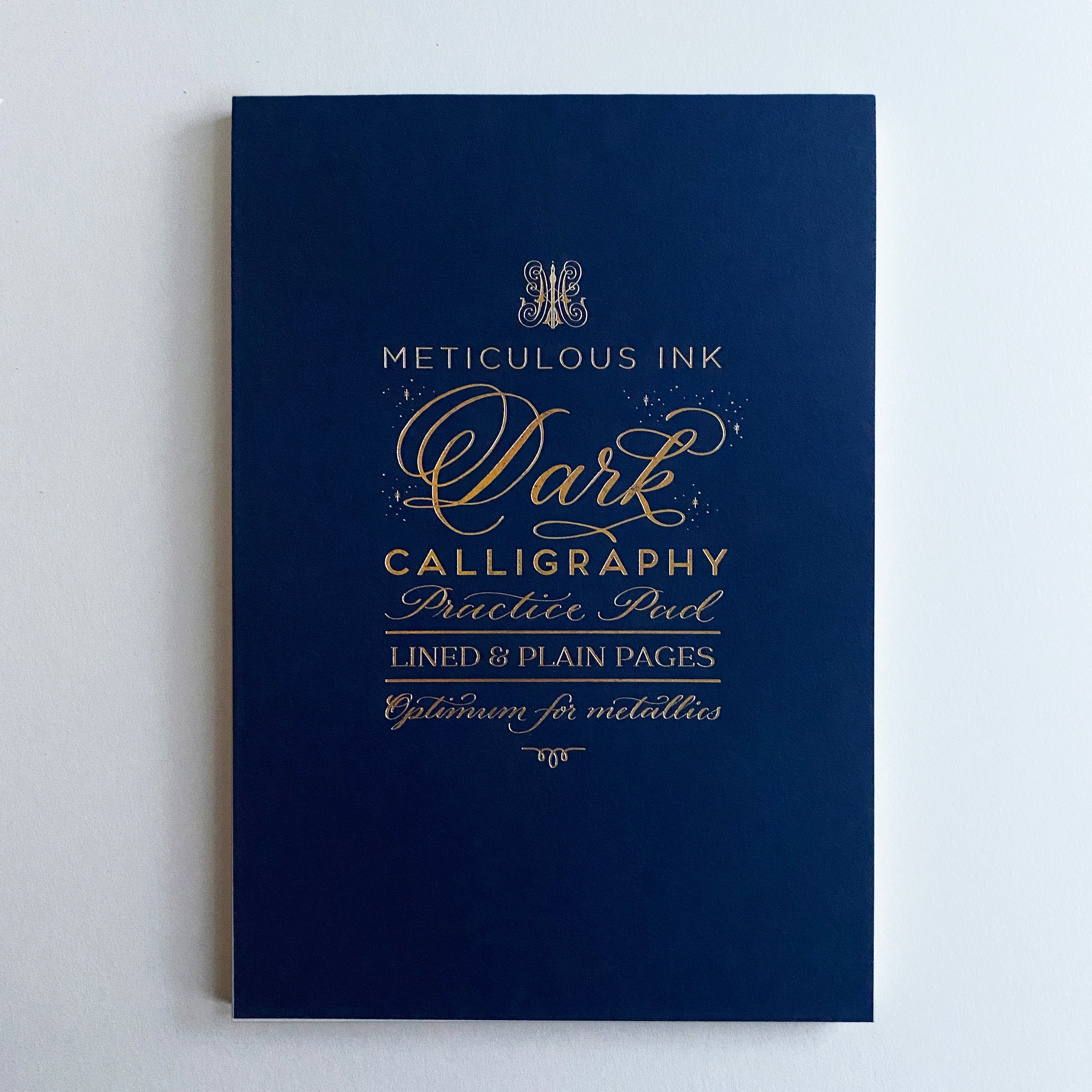 Dark calligraphy practice pad with gold lettering