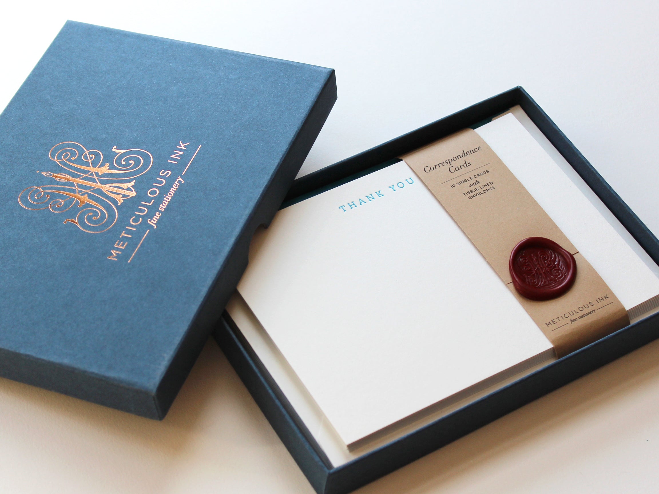 Teal Serif Thank You Letterpress Correspondence Cards in display box with wax seal and Meticulous Ink logo on box