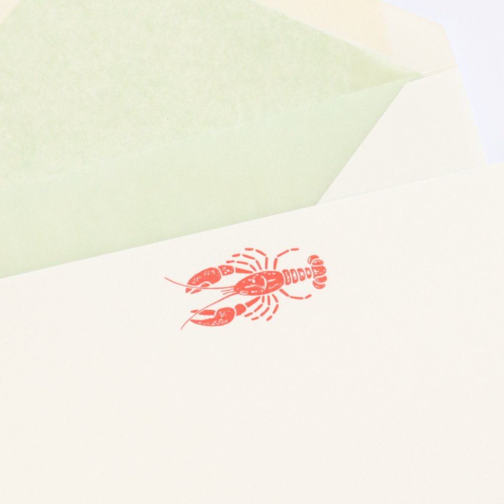 Close-up of red Letterpress Lobster and green tissue lined envelope