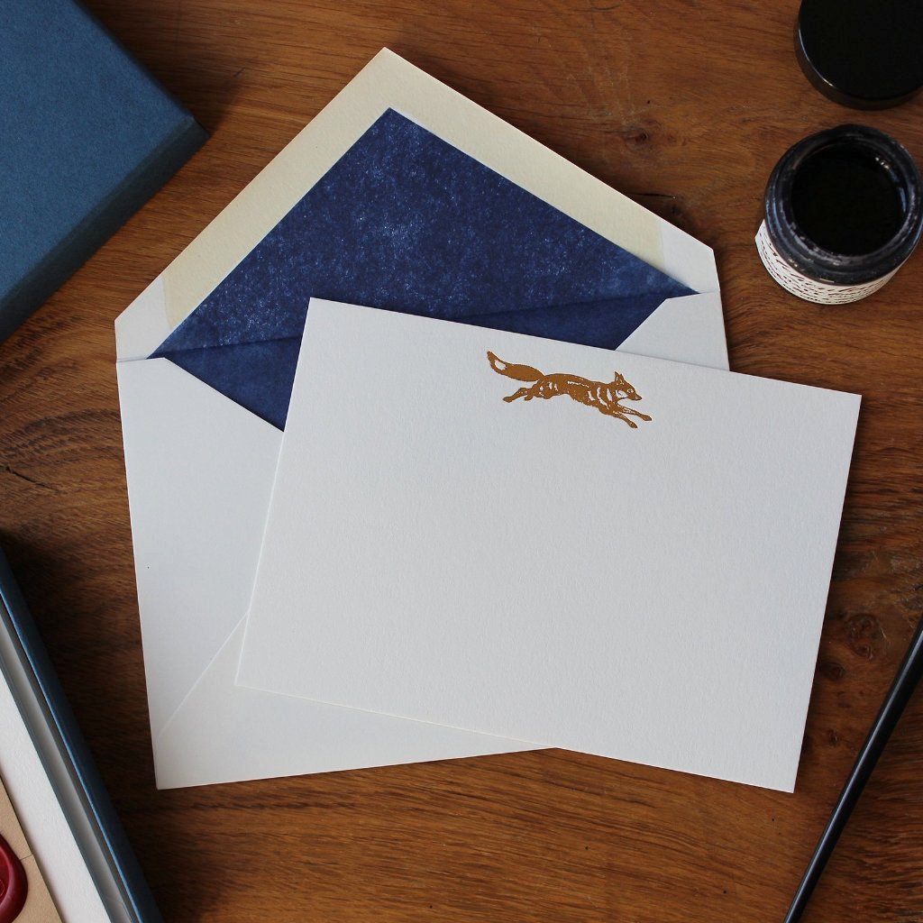 Copper Foil Fox Correspondence Card with dark blue tissue lined envelope and ink pot on wood desk