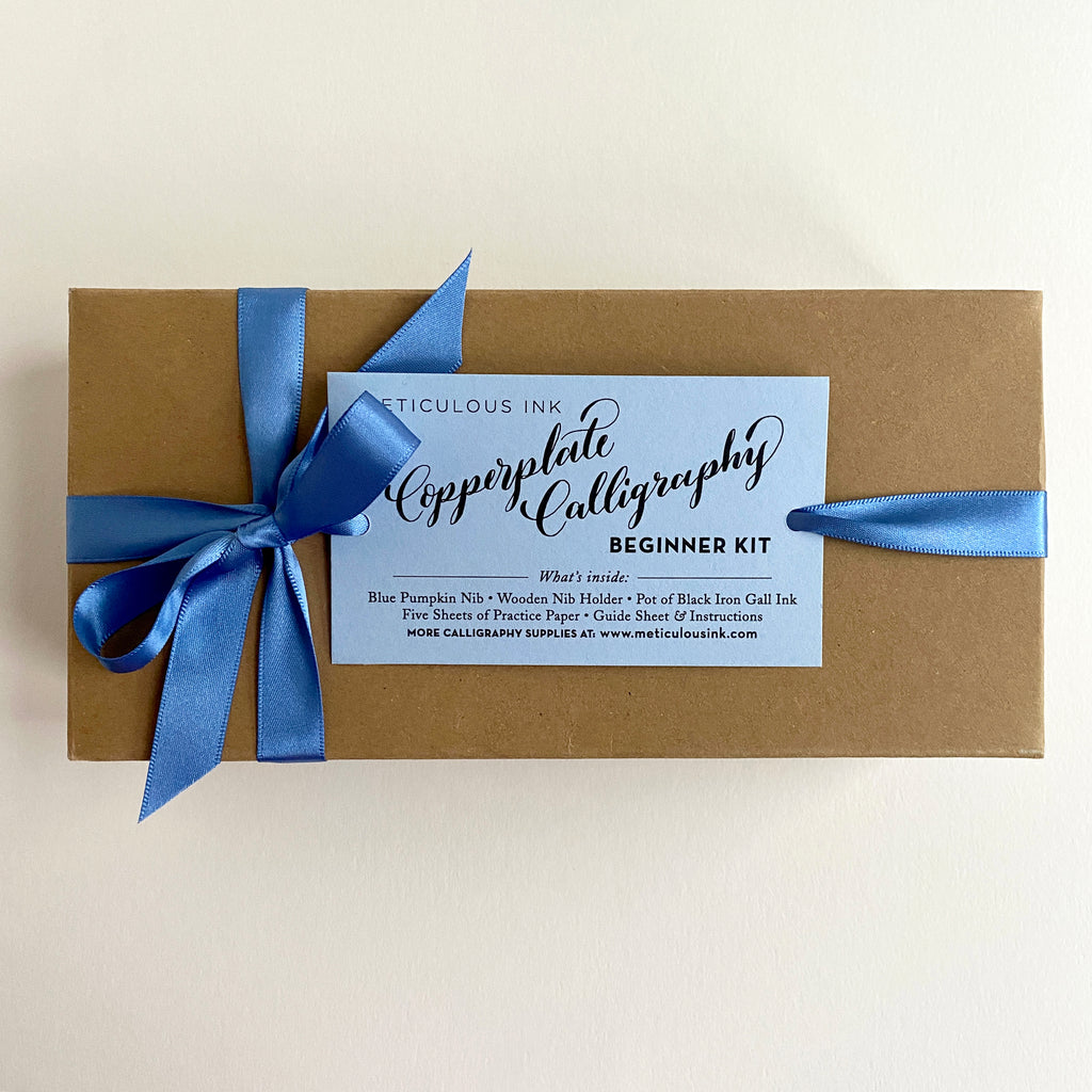 Kraft box with blue ribbon and Copperplate Calligraphy kit label