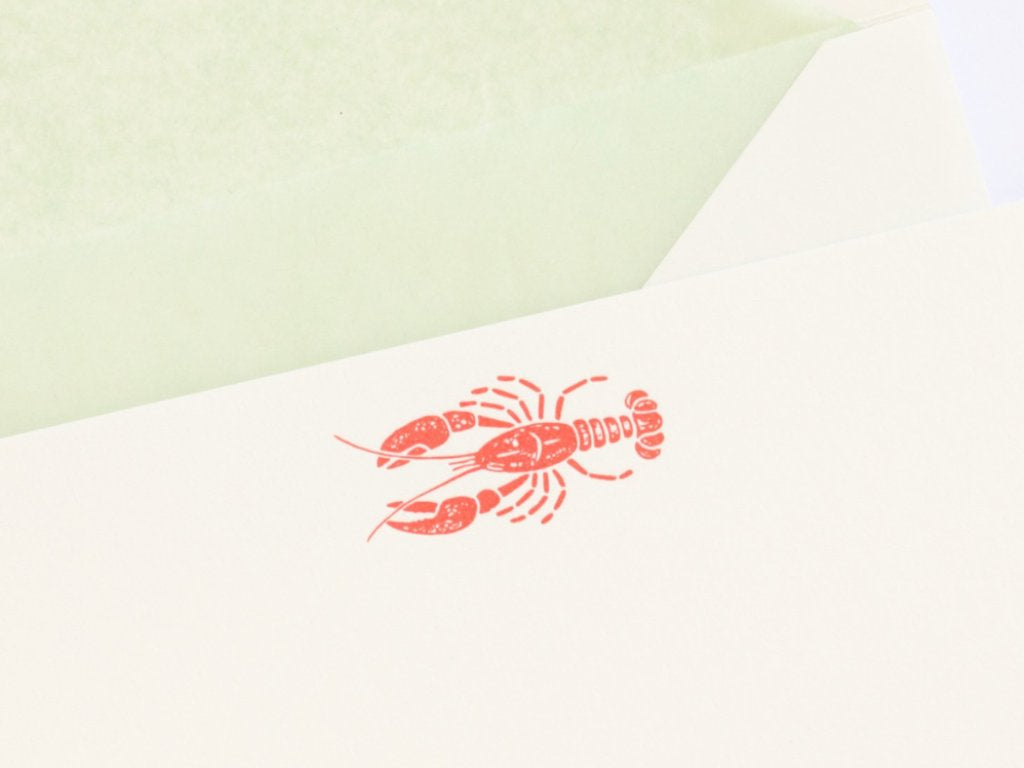 Close-up of red Letterpress Lobster and green tissue lined envelope